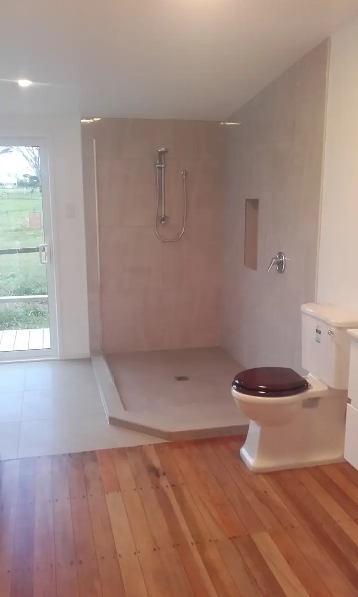 Walk-in tiled shower and toilet in a renovated Whangarei bathroom by Lambly Builders